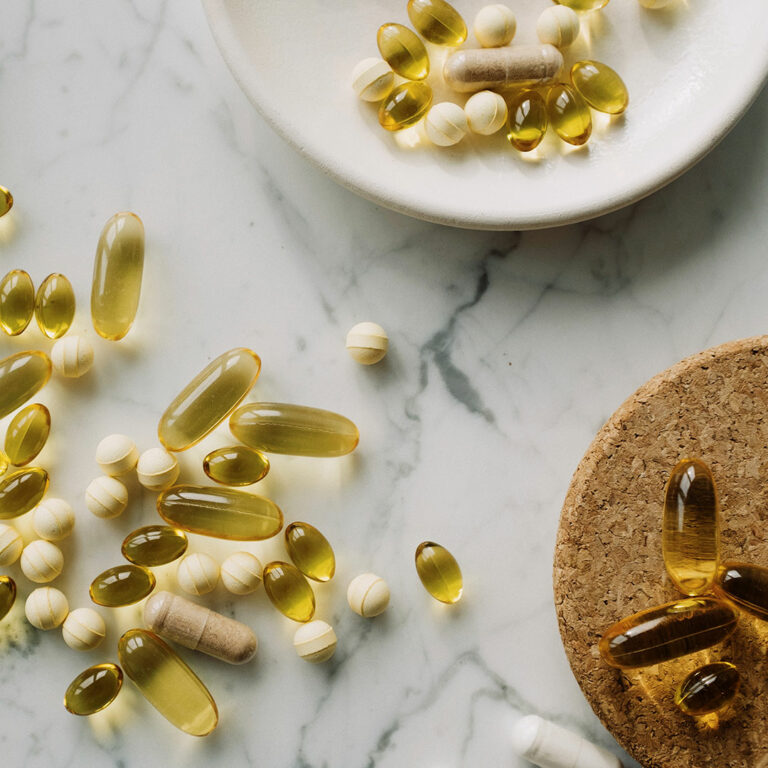 kitchen tabletop with softgels and pills laying out | cellular health